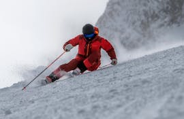 Un hombre esquiando montaña abajo durante sus clases particulares de esquí para adultos de todos los niveles con Schischule Glungezer.