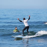 A person surfing during a private surf lesson on Praia de Ribeira d'Ilhas with Ericeira Waves.