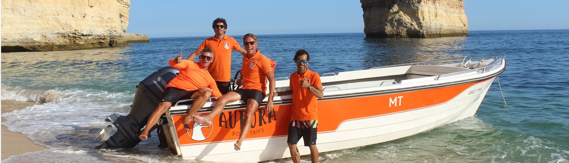 Unsere Crew mit dem Boot während einer Bootstour von Armação de Pêra zu 15 Höhlen einschließlich Benagil mit Aurora Boat Trips.