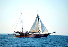 Ein elegantes Holzboot steht im türkisblauen Wasser des icarischen Meers während der Segelbootstour nach Kalymnos, Plati & Pserimos ab Kos mit Odyssey Boat Kos.