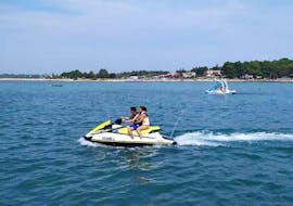 Ein Paar hat spaß auf einem Jetski und fahren über das Wasser beim Jetski-Verleih in Umag mit Levante Watersports Umag.