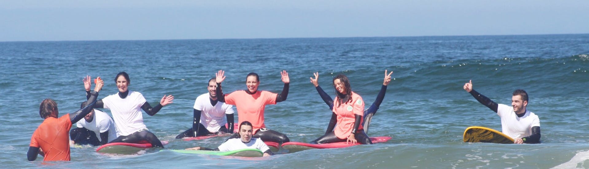 Un gruppo di persone con le loro tavole da surf durante una lezione di surf vicino a Porto con Pura Vida Surfing School.