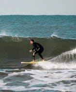 A person surfs during a private surf lesson near Porto in Vila Nova de Gaia with Pura Vida Surfing School.