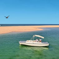 Ein Boot am wunderschönen blauen Wasser während der Bootstour entlang der Ria Formosa mit Vogelbeobachtung mit Lands Algarve.