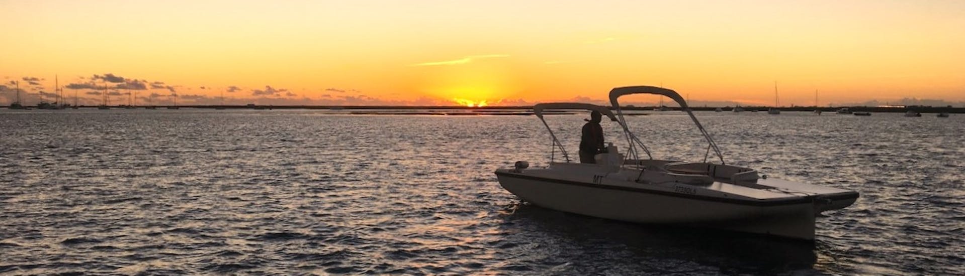 Eine Gruppe von Teilnehmern genießt einen schönen Sonnenuntergang über der Ria Formosa während einer Bootstour bei Sonnenuntergang von Faro aus entlang des Flusses mit Lands Algarve.