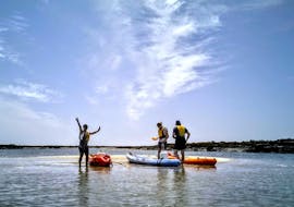 A group of participants enjoying a day out kayaking, stopping on one of the islets of the Ria Formosa during a kayak tour from Faro with Lands Algarve.