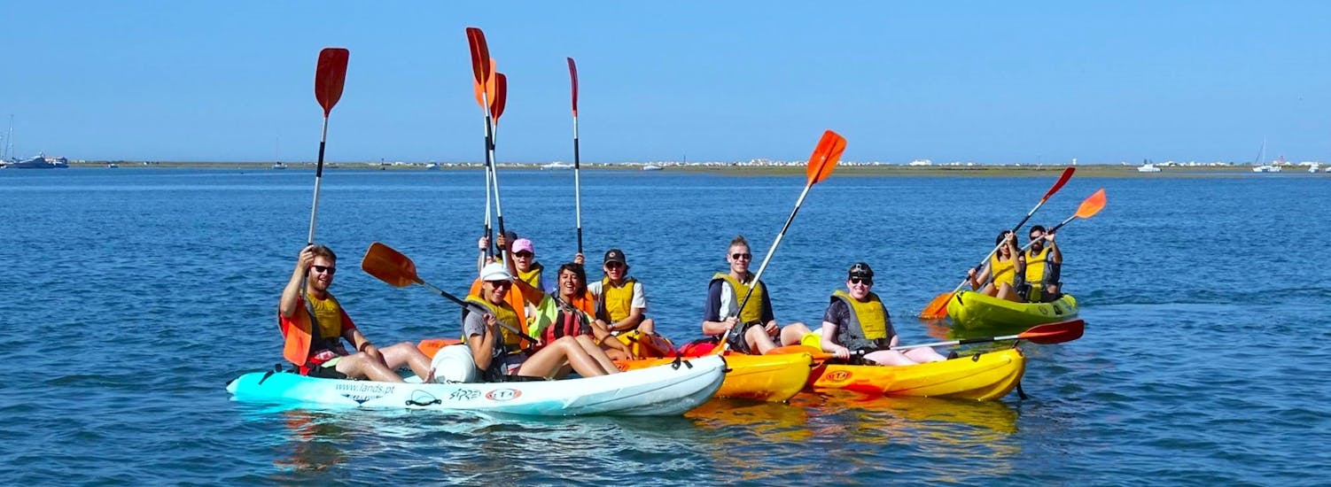 A group of participants paddling down the Ria Formosa on a sunny day during a kayak tour from Faro with Lands Algarve.