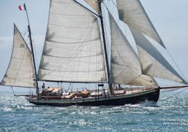 People are doing a Boat Trip in the Gulf of Morbihan on a Vintage Sailboat with Lys Noir Morbihan.