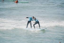 An instructor teaching a person to surf during a Private Surf Lessons on Praia do Matadouro