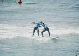 Ein Surflehrer bringt einer Person während eines privaten Surfkurses am Praia do Matadouro das Surfen bei.