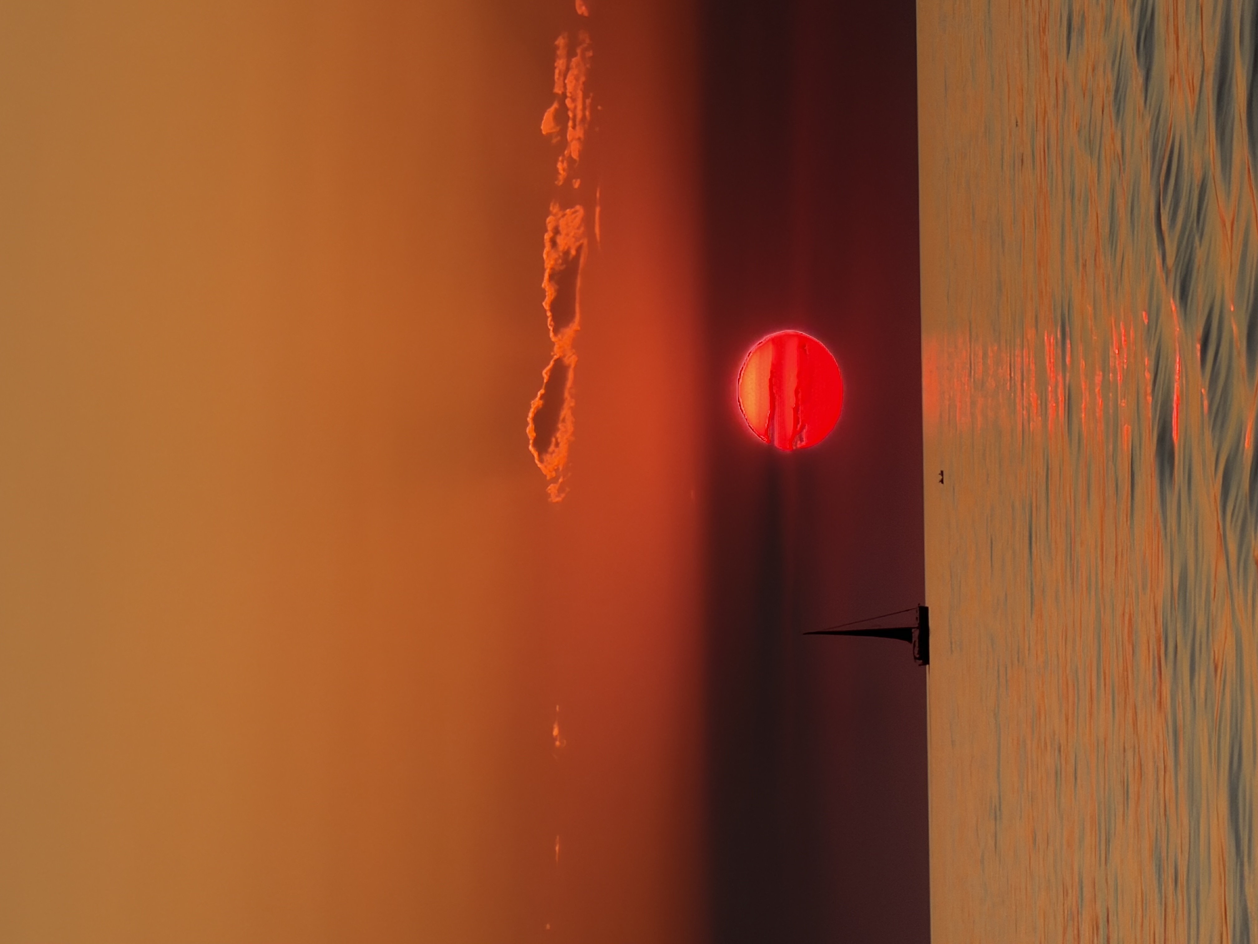 La silueta de un barco en el mar en calma contra un sol rojo brillante durante una excursión privada al atardecer desde Fažana con Sea Tours Istria Fažana.