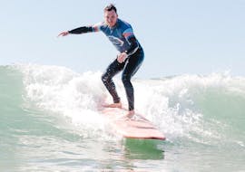 A guy riding a wave during Surf Lessons on Carcavelos or Guincho Beach in Cascais with Surf Cascais.