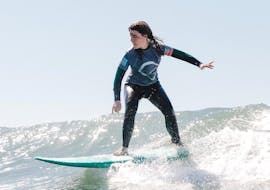 A woman riding the waves during Private Surf Lessons on Carcavelos or Guincho Beach in Cascais with Surf Cascais.