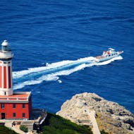 Das Boot von HP Travel bei der Fahrt vor dem Leuchtturm von Anacapri während des Tagesausflugs von Neapel nach Capri mit geführter Tour der Insel.
