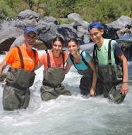Vier mensen glimlachen in de rivier tijdens de riviertrekking in de Gole dell'Alcantara met Sicily Adventure Taormina.
