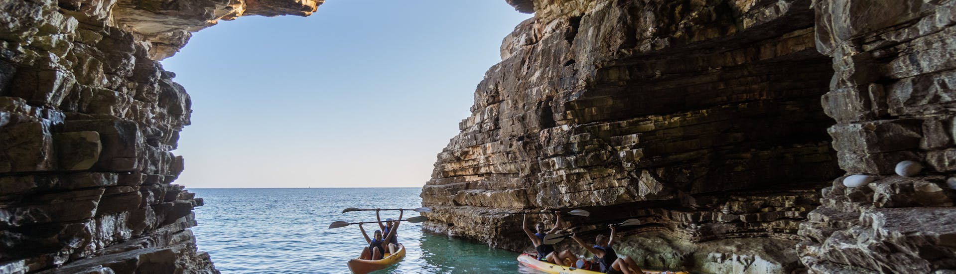 Die Teilnehmer der halbtägigen Kajaktour mit Schnorcheln mit Kayaking Premantura erkunden die Küste auf ihren Kajaks.