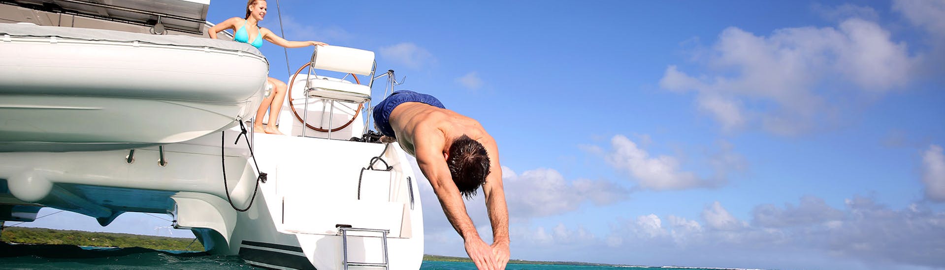 Ein Mann springt ins Meer auf einer Segelkatamaran-Tour von Protaras zur Blauen Lagune mit Paphos Sea Cruises.