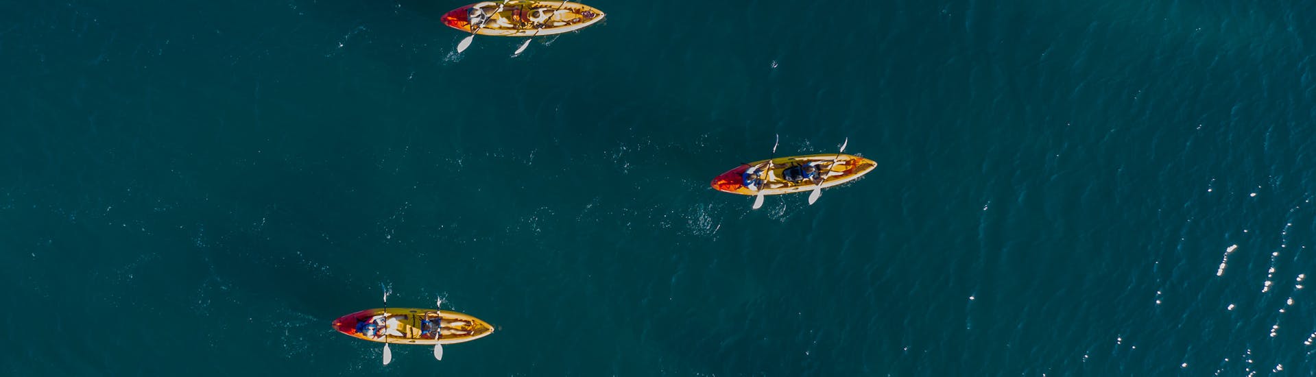 Quatre kayak sur l'eau pendant la randonnée en kayak de mer d'une journée à Premantura avec snorkeling avec  Kayaking Premantura.