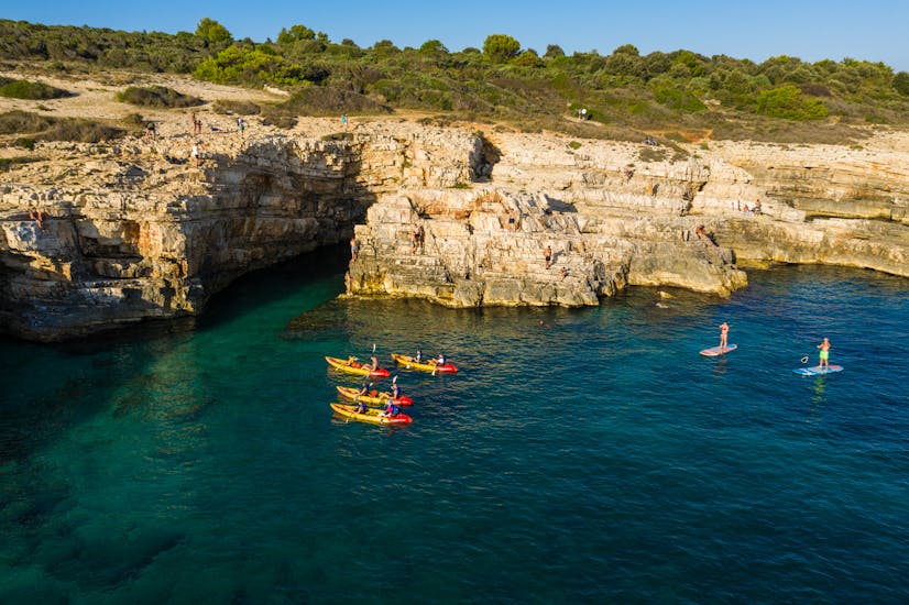Four kayaks in the sea during the kayaking excursion to the cave of Cape Kamenjak with snorkeling with Kayaking Premantura.