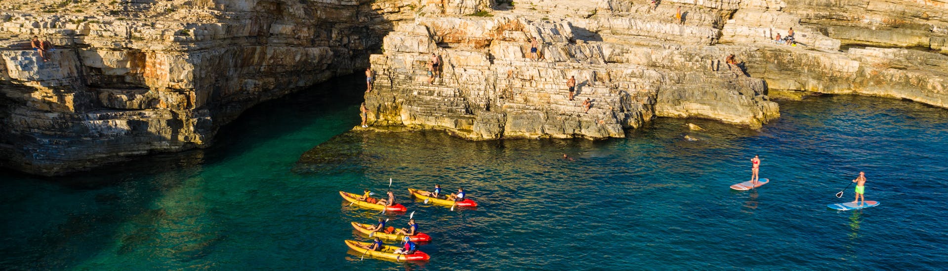 Four kayaks in the sea during the kayaking excursion to the cave of Cape Kamenjak with snorkeling with Kayaking Premantura.