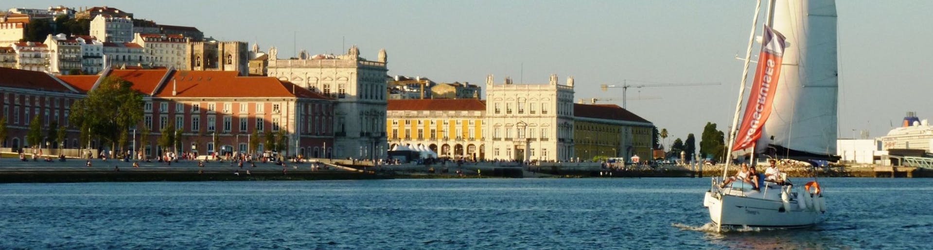 Un voilier avec la ville historique de Lisbonne en arrière-plan, lors d'une balade en bateau l'après-midi avec Taguscruises Lisbon.