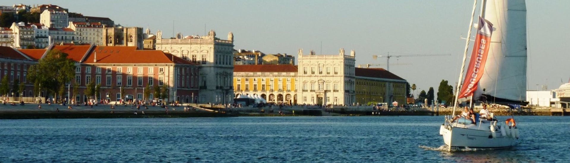 Un velero con la histórica ciudad de Lisboa como fondo, durante un paseo en barco por la tarde con Tagus Cruises Lisboa.