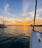 The sun setting over the Tagus River while participants enjoy the view during a sailing boat trip in Lisbon with Taguscruises Lisbon.
