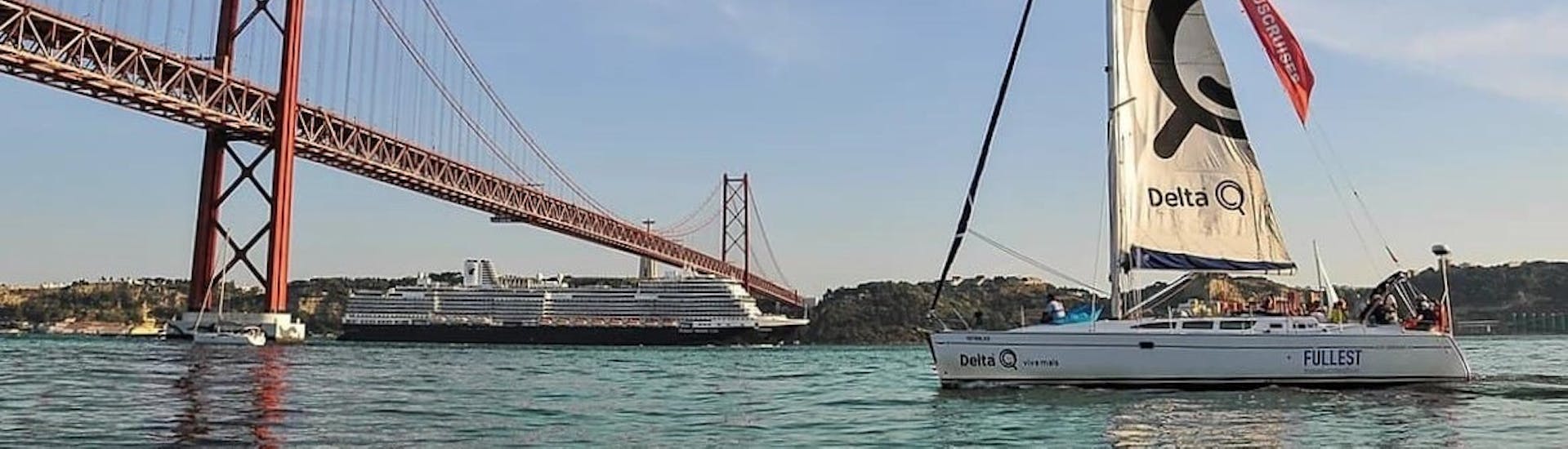 La hermosa ciudad de Lisboa de fondo, mientras un elegante velero navega hacia una playa cercana durante un viaje privado en barco desde Lisboa con Tagus Cruises Lisboa.