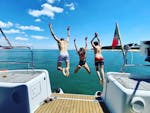 Tres niños saltan para darse un refrescante chapuzón en las aguas azules durante un viaje en barco privado desde Lisboa con Tagus Cruises Lisboa.