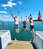 Trois enfants sautent pour un plongeon rafraîchissant dans les eaux bleues lors d'une balade privée en bateau au départ de Lisbonne avec Taguscruises Lisbon.