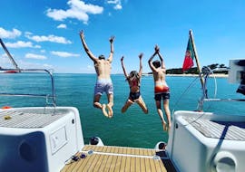 Drei Kinder springen für einen erfrischenden Sprung ins blaue Wasser während einer privaten Bootstour ab Lissabon mit Taguscruises Lisboa.