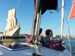 Una pareja disfrutando de la vista del Monumento a los Descubrimientos, en un día soleado en el río Tajo, durante un viaje en barco privado desde Lisboa con Tagus Cruises Lisboa.