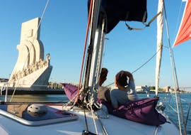 Un couple appréciant la vue du Monument des Découvertes, par une journée ensoleillée sur le fleuve Tage, lors d'une balade privée en bateau au départ de Lisbonne avec Taguscruises Lisbonne.