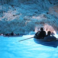 Blick in das Innere der Blauen Grotte, wo die Menschen während der Bootstour um Capri mit Halt an der Blauen Grotte mit HP Travel in kleinen Booten paddeln.