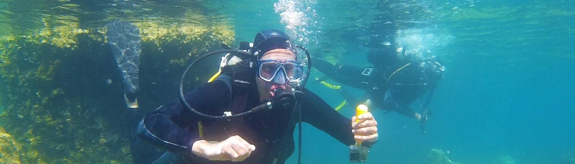 Un homme fait son baptême de plongée sous-marine dans la baie de Kontokali avec Scubanauts Corfu Diving Center.