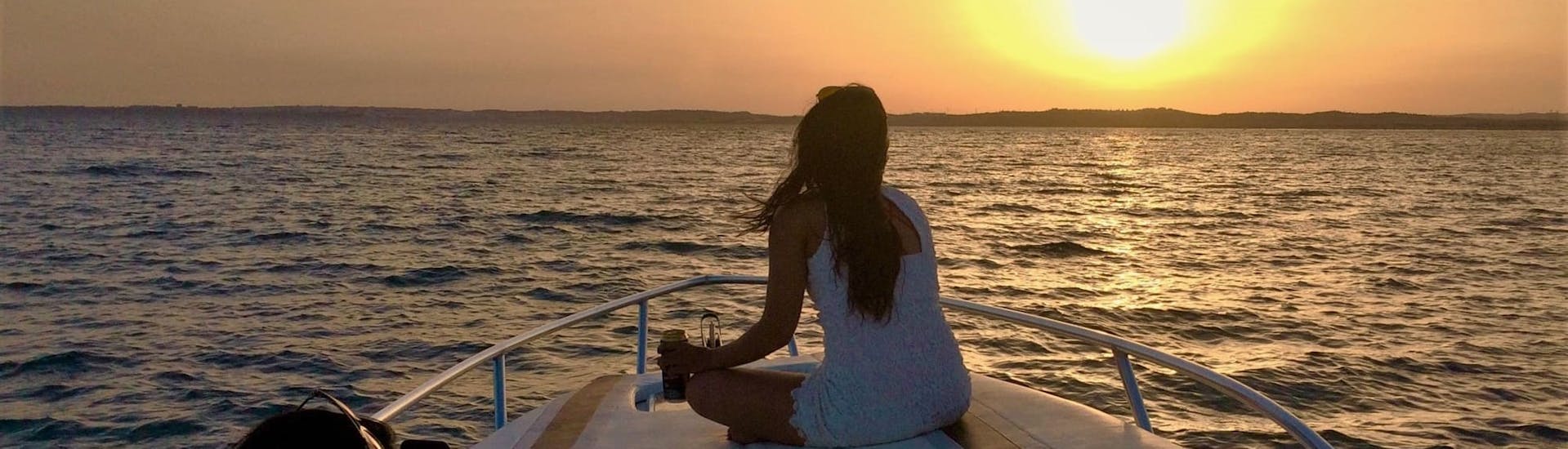 Eine Frau genießt den Sonnenuntergang während der Private Bootstour bei Sonnenuntergang zur Benagil-Höhle mit Seasiren Tours Algarve.