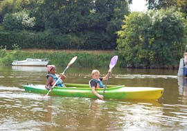 Deux enfants pagayant pendant une sortie Canoë-kayak sur la Mayenne près d'Angers avec Canotika Tourisme Mayenne.