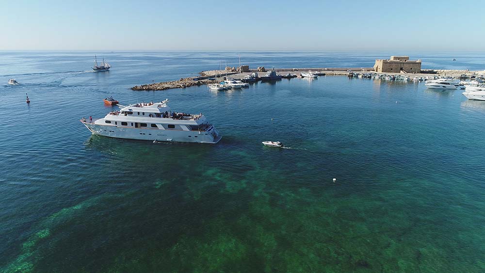 Die Ocean Flyer ankert während eines Luxusyachttour zur Korallenbucht und zu den Meereshöhlen - nur für Erwachsene mit Paphos Sea Cruises.