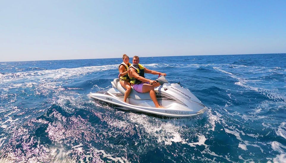 Una coppia su una moto d'acqua durante il noleggio di una moto d'acqua da 130 HP sulla spiaggia di Kamari a Santorini.