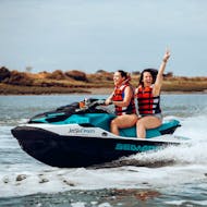 Dos amigas se divierten chapoteando en una emocionante moto de agua por la costa de Isla Canela e Isla Cristina durante un safari en moto de agua con Jet Ski Dreams Huelva.