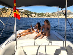 Twee vrienden met een glas cava genietend van het uitzicht op de zuidwestelijke regio van Mallorca tijdens een privéboottocht met zwemmen met Mallorca from the sea.