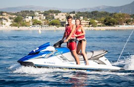Una giovane coppia è in piedi nella loro moto d'acqua di fronte a uno splendido paesaggio della Riviera francese mentre è su una moto d'acqua a Cagnes-sur-Mer vicino a Nizza con Cagnes Watersports.