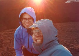 Two people taking a selfie on Mount Etna at the light of sunset during the Sunset Jeep Tour on Etna with Tasting of Sicilian Products with Etna & Sea Excursions Catania.