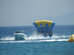 Le bateau tractant la bouée Fly Fish à travers la mer depuis le Sofa, Crazy UFO & Fly Fish à Paradise Beach à Kos avec Water Club Paradise Beach Kos.