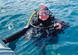 Jeune fille avec un équipement de plongée sous-marine dans l'eau pendant l'initiation à la plongée sous-marine à Aci Castello près de Catane avec Etna & Sea Excursions Catania.