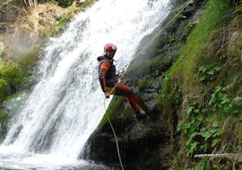 Un chico escalando mientras hace barranquismo en el río Navedo para familias con Cantabria Activa.
