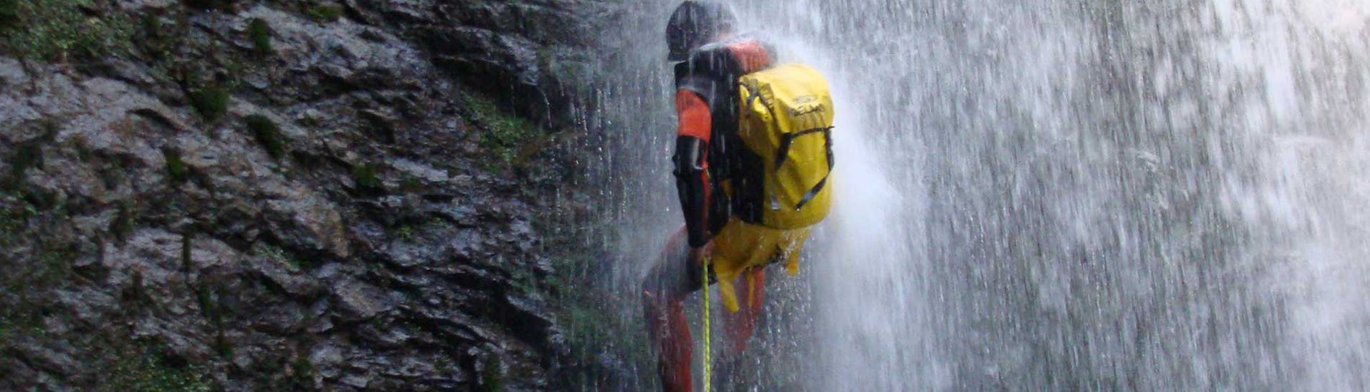 A guy in the waterfall while Canyoning in the Navedo River for Families with Cantabria Activa.