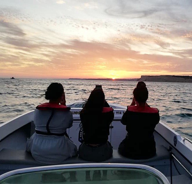 Ein wunderschöner Sonnenuntergang über der Küste der Algarve mit leuchtend orangen und gelben Farben während einer Bootstour zum Sonnenuntergang von Lagos nach Carvoeiro mit Funtastik Tours Lagos.