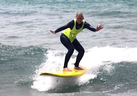 A woman surfing during Surf Lessons (from 12 y.) for All Levels in Ericeira with Activity Surf Center.