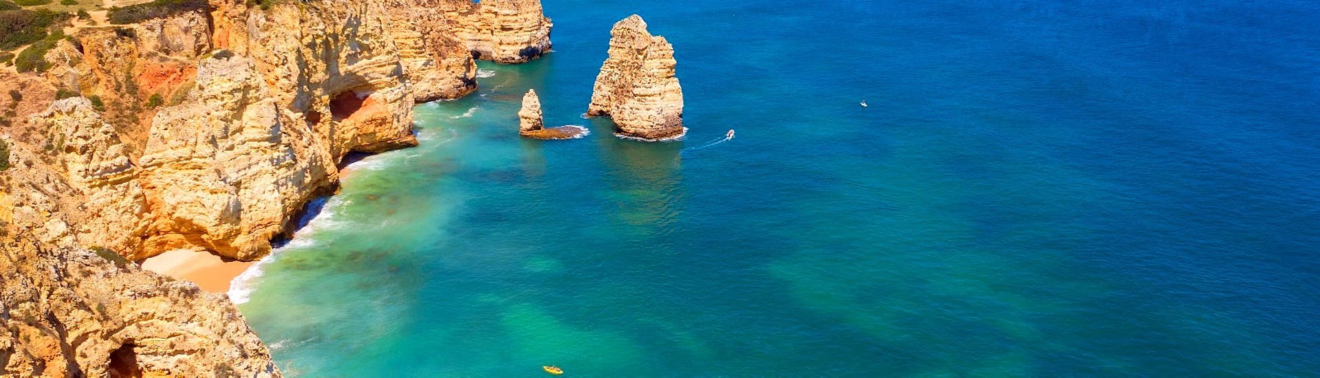 Die schöne Aussicht auf einige Höhlen und Grotten entlang der Küste der Algarve während einer privaten romantischen Bootstour zum Sonnenuntergang ab Lagos mit Funtastik Tours Lagos.